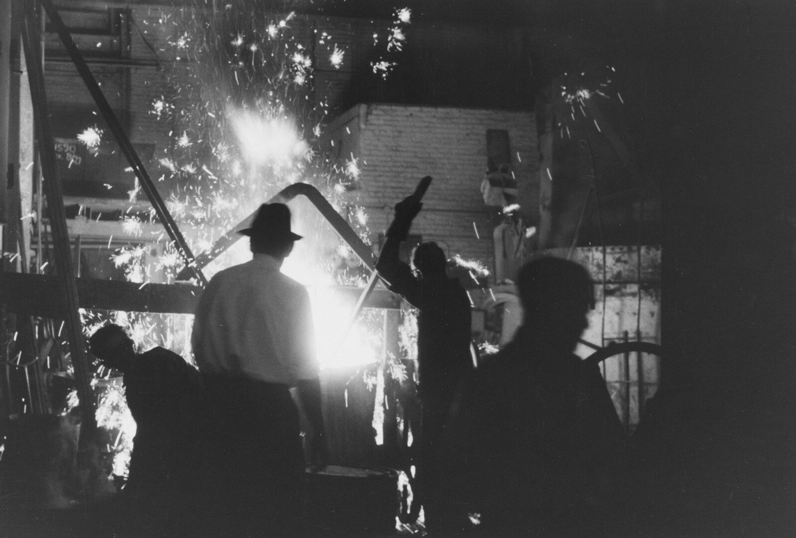 Workers in a foundry with sparks flying