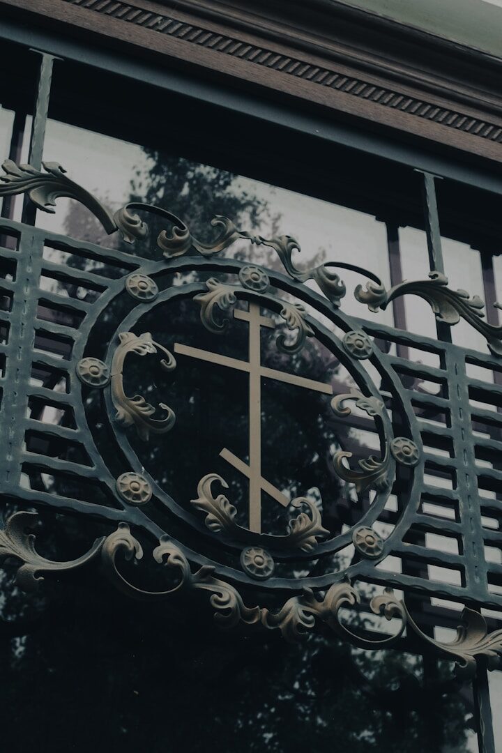 Ornate metal gate with eastern orthodox cross emblem