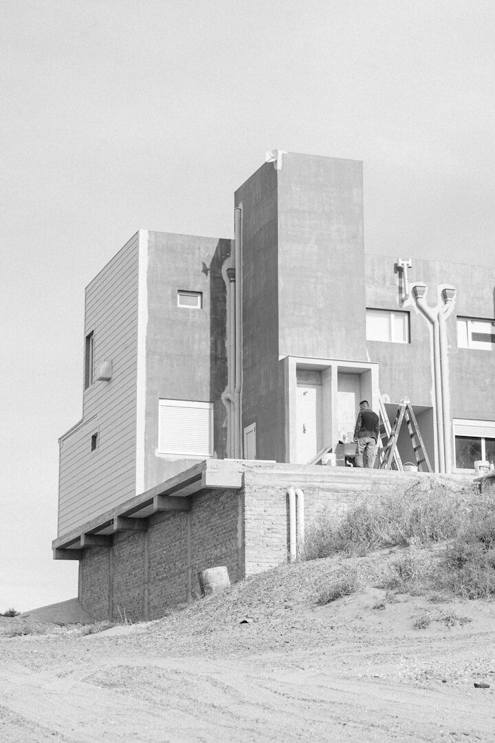 Man painting a modern building exterior on a ladder