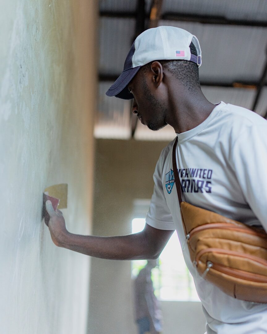 Man plastering a wall with a trowel.